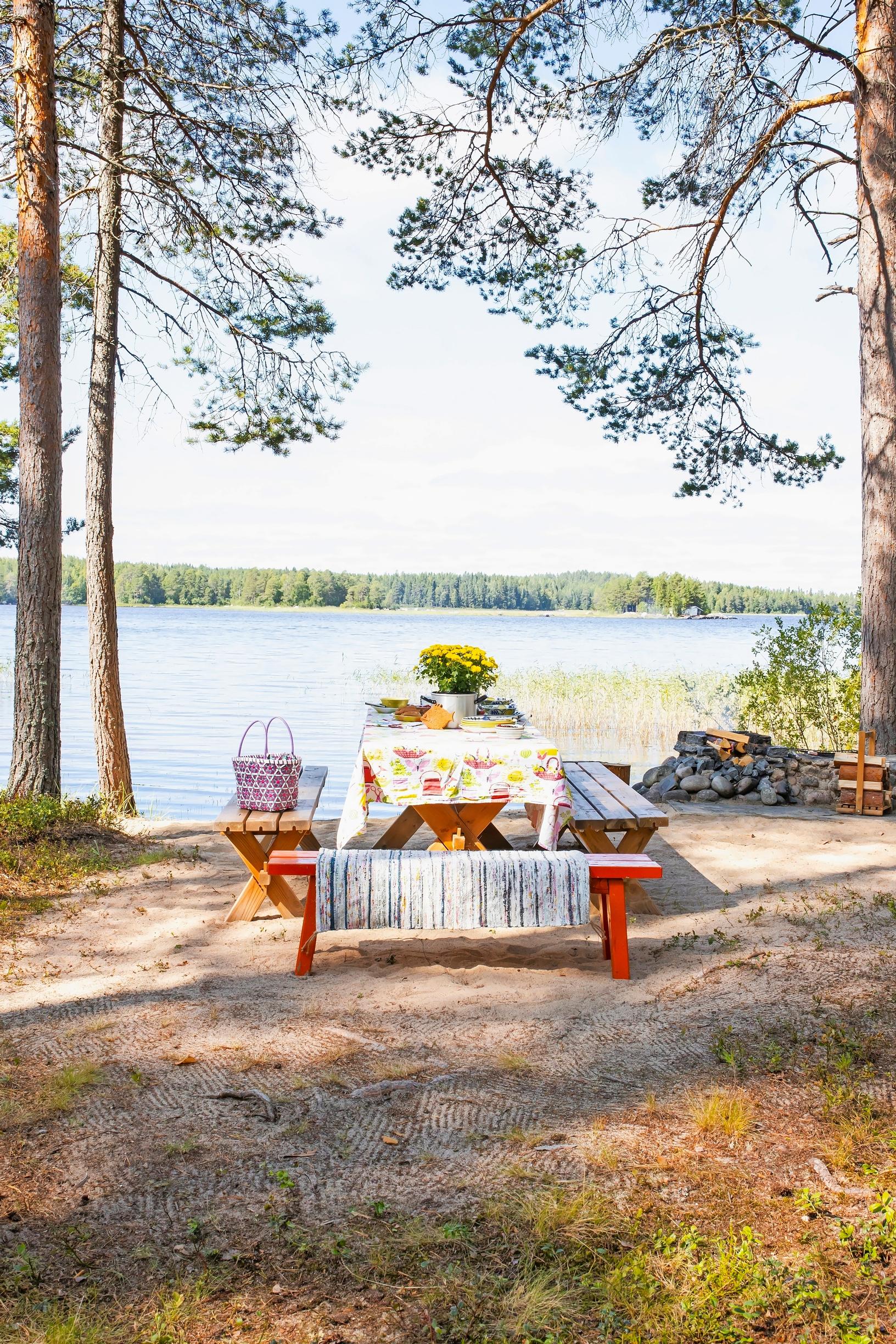Pirttipöytä ja penkit järvenrannalla