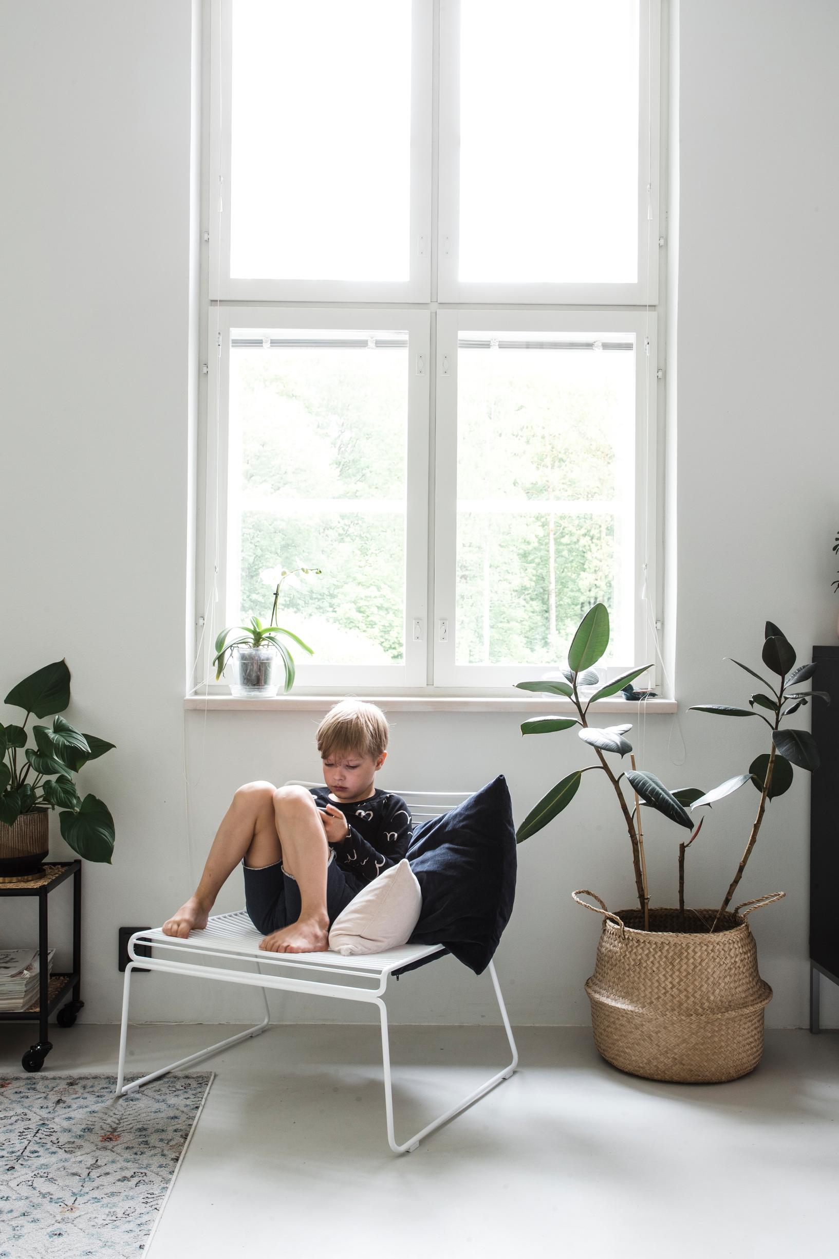 Poika istuu nojatuolilla