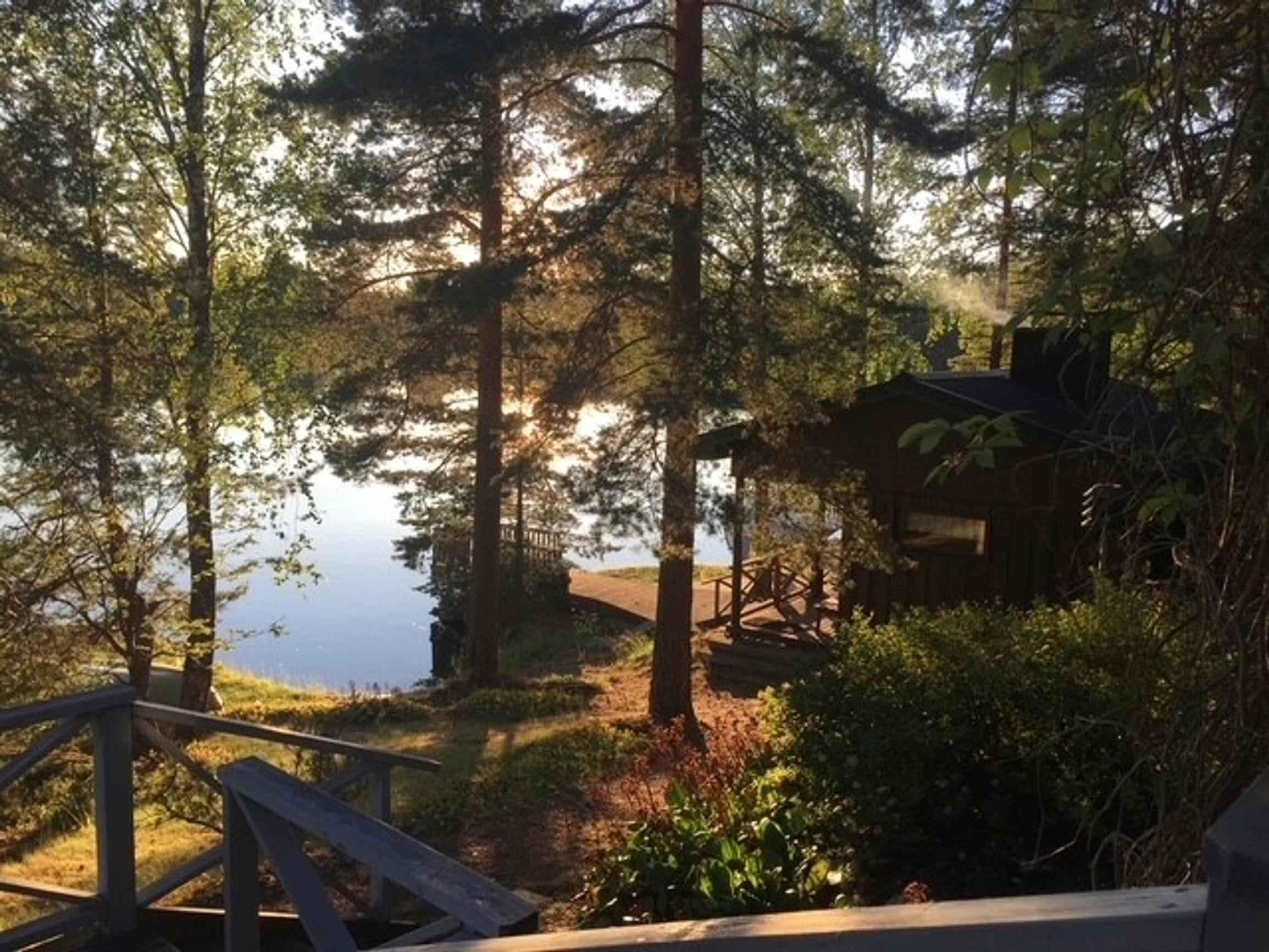 Arja Korisevan kesämökin terassilta näkymä järvelle, ilta-aurinko ja rantasauna