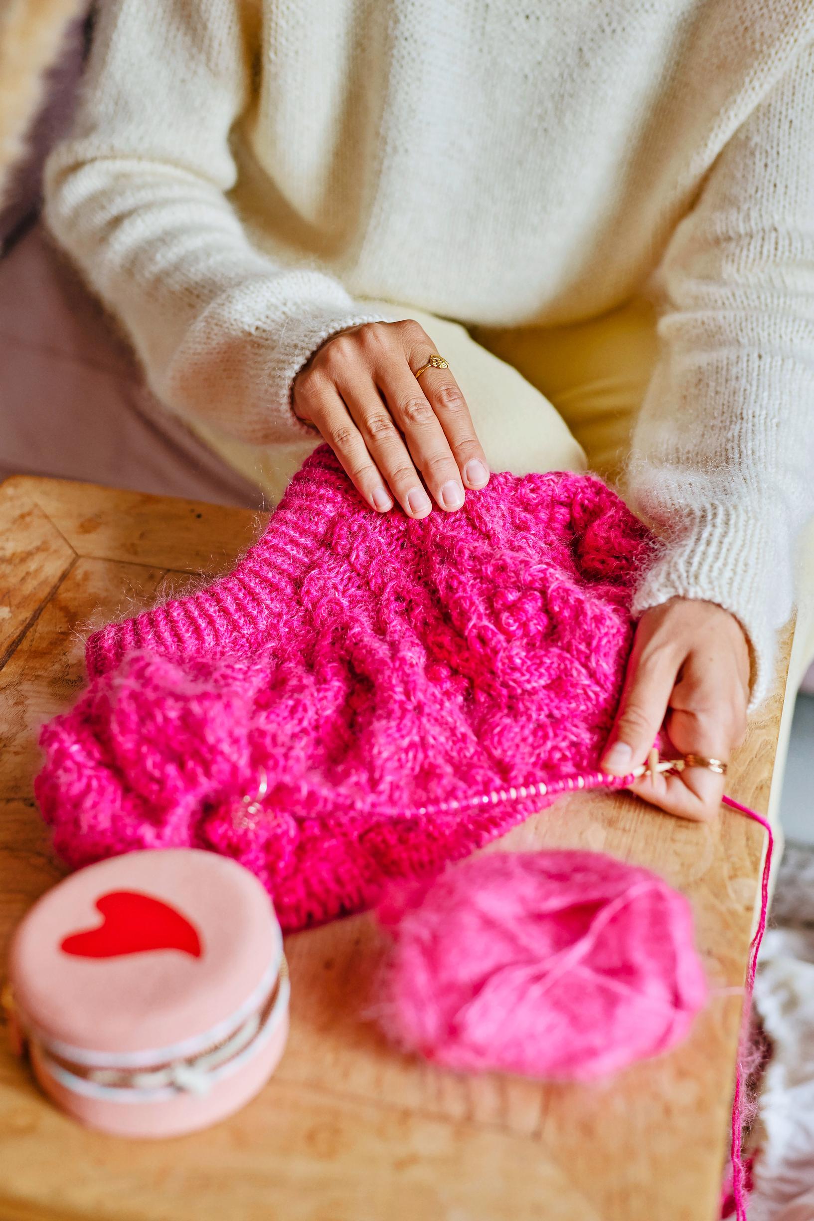 Pinkki keskeneräinen neule puikoilla