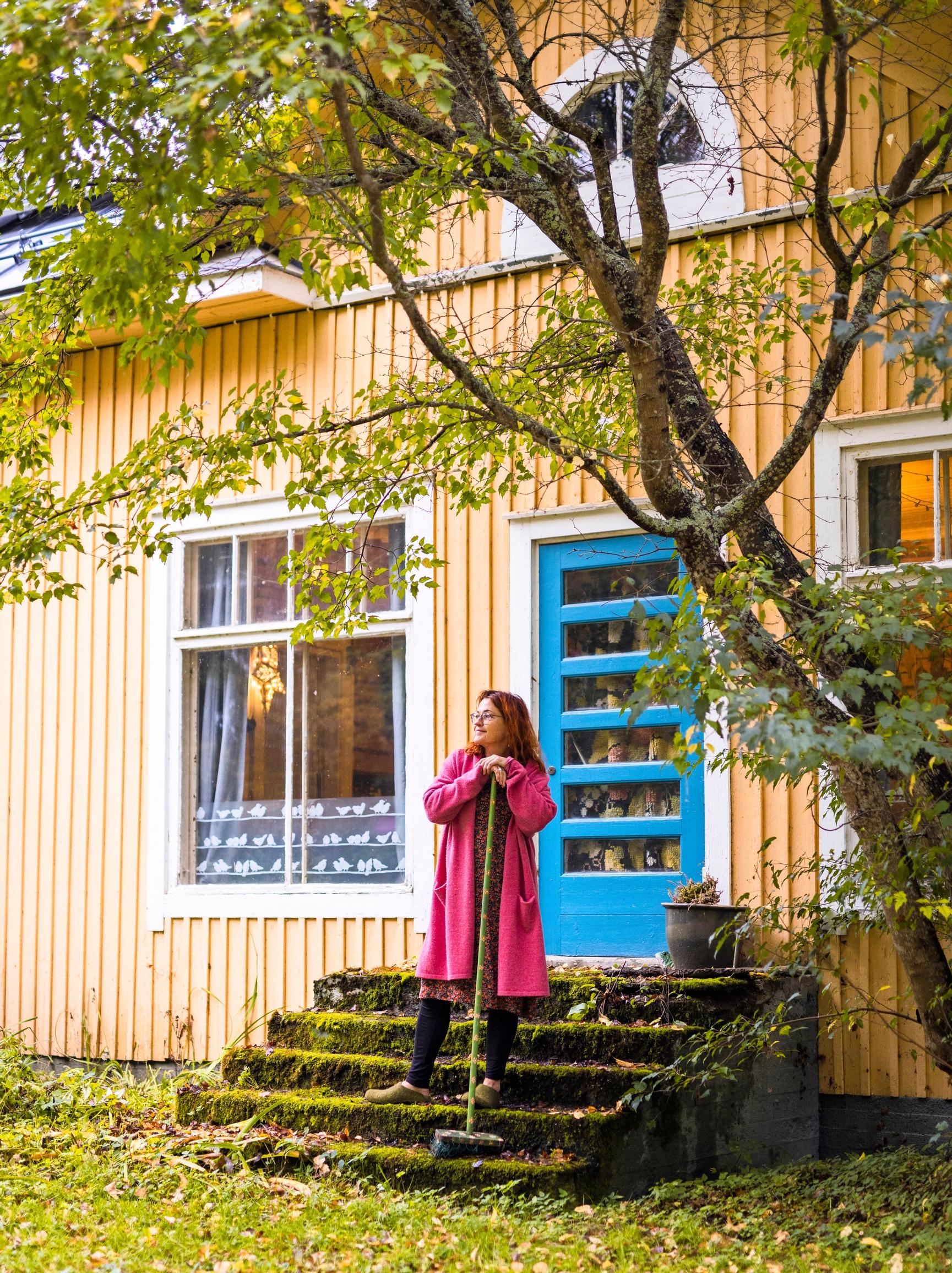 Arja heinilä lakaisee kotinsa rappusia