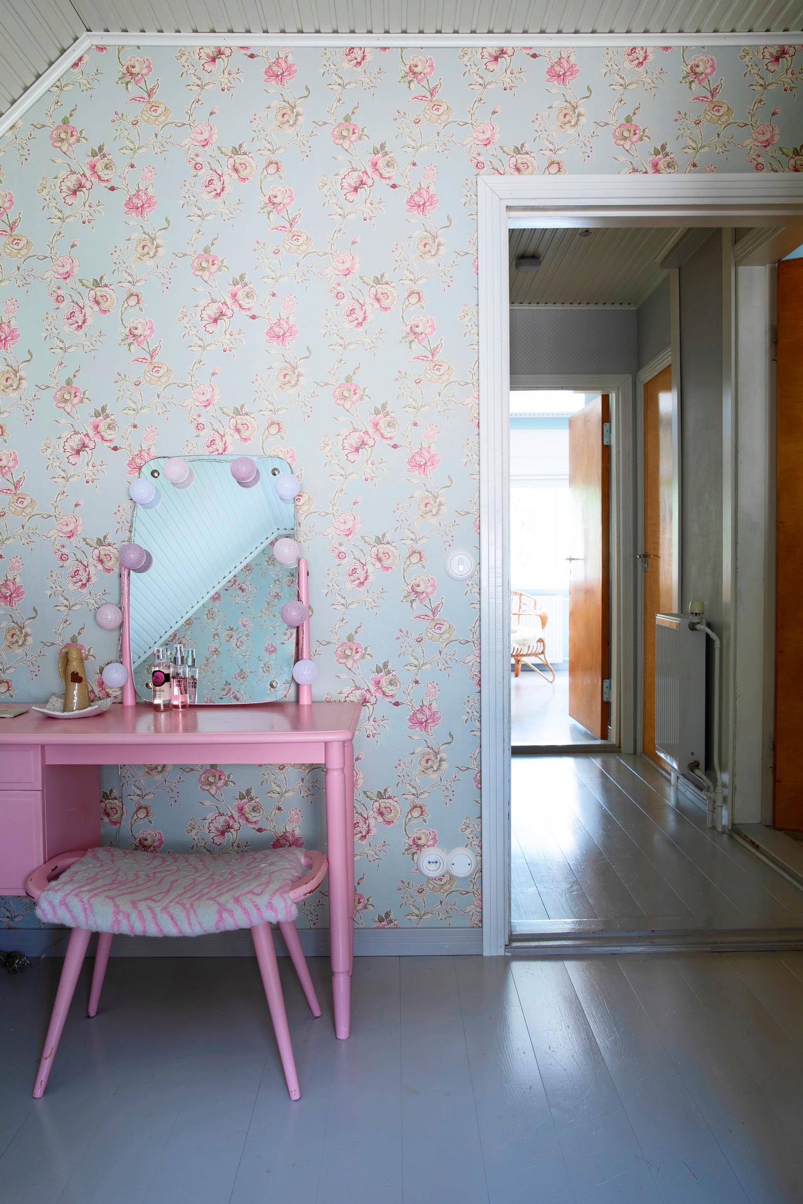 Tyttären huoneessa on vaaleanpunainen peilipöytä ja vaaleansinipohjainen ruusutapetti