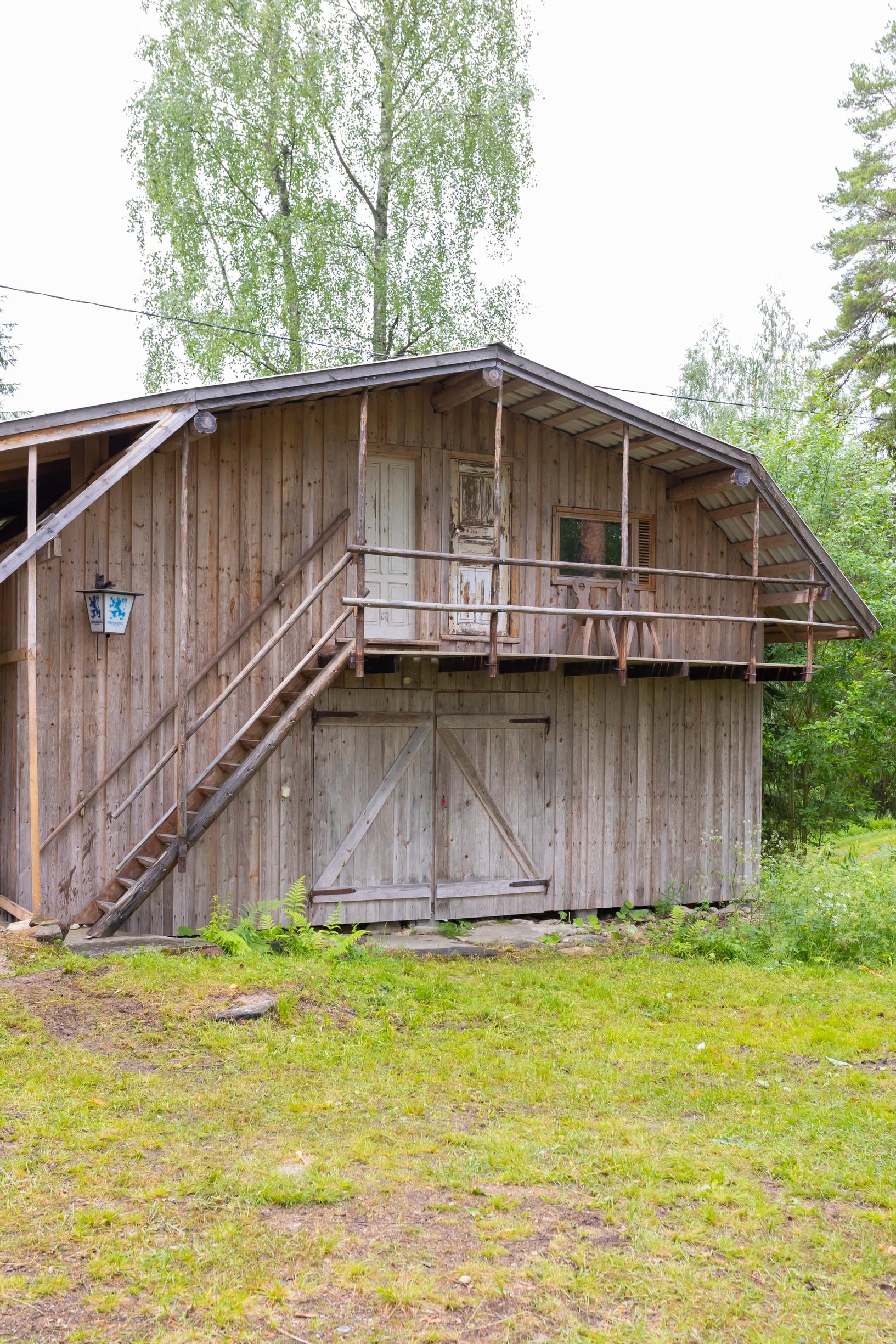 vanha hirsirakennus ja kulunutta nurmikkoa