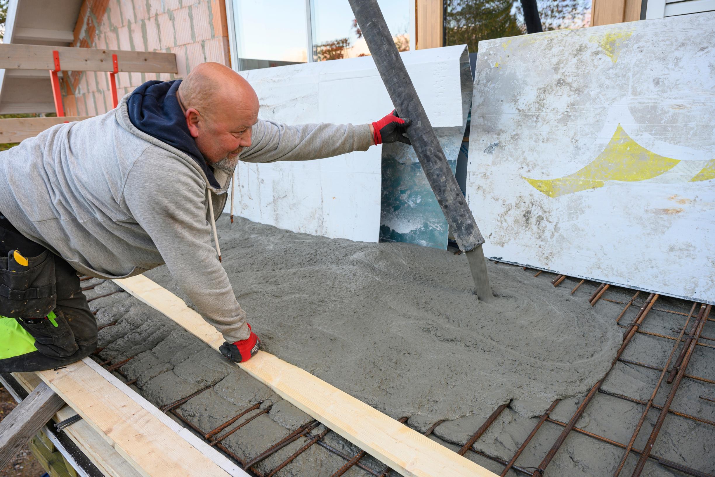 Antti Tikkanen valaa betonia parvekkeelle.