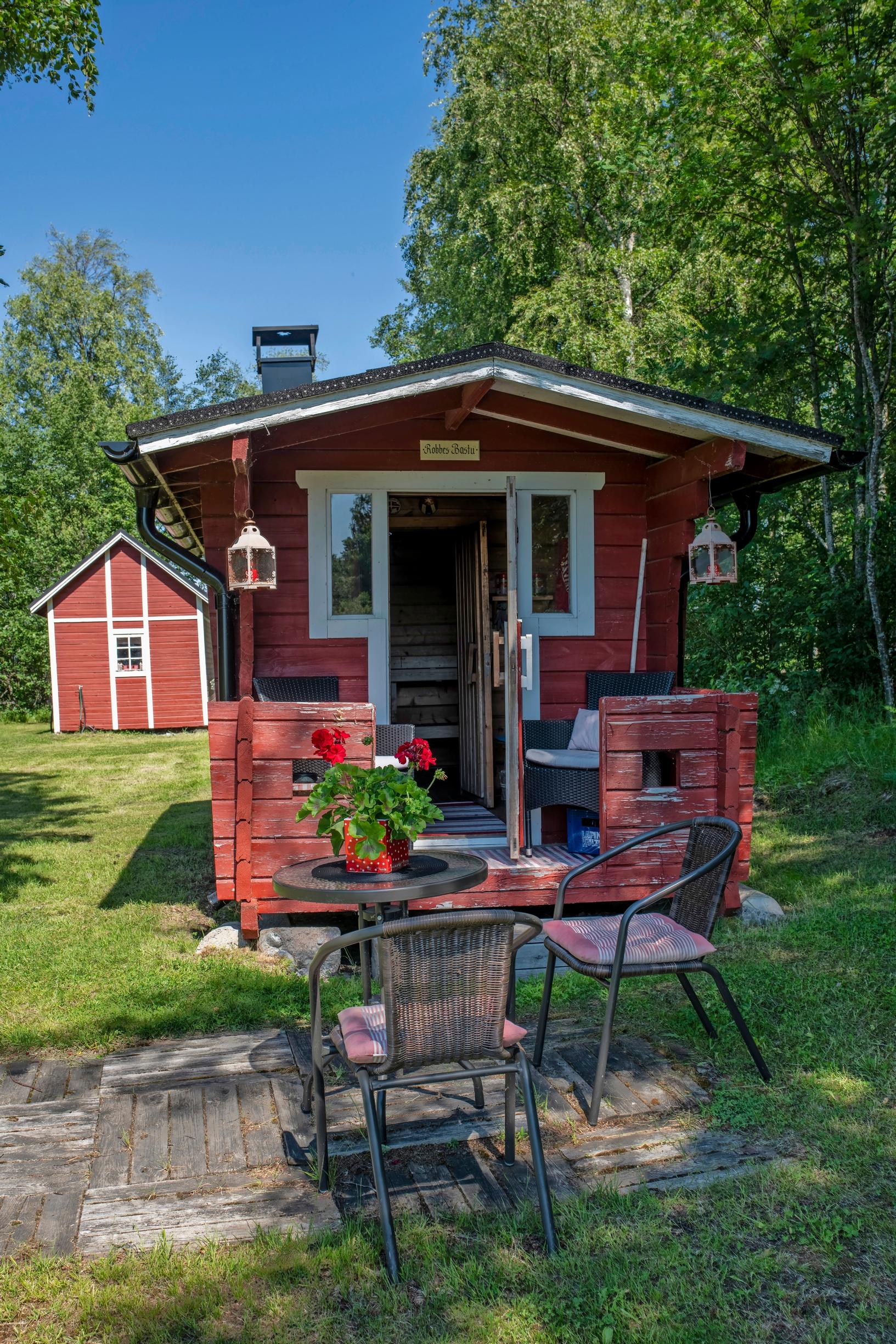 punainen pihasauna ja puutarhakalusteet
