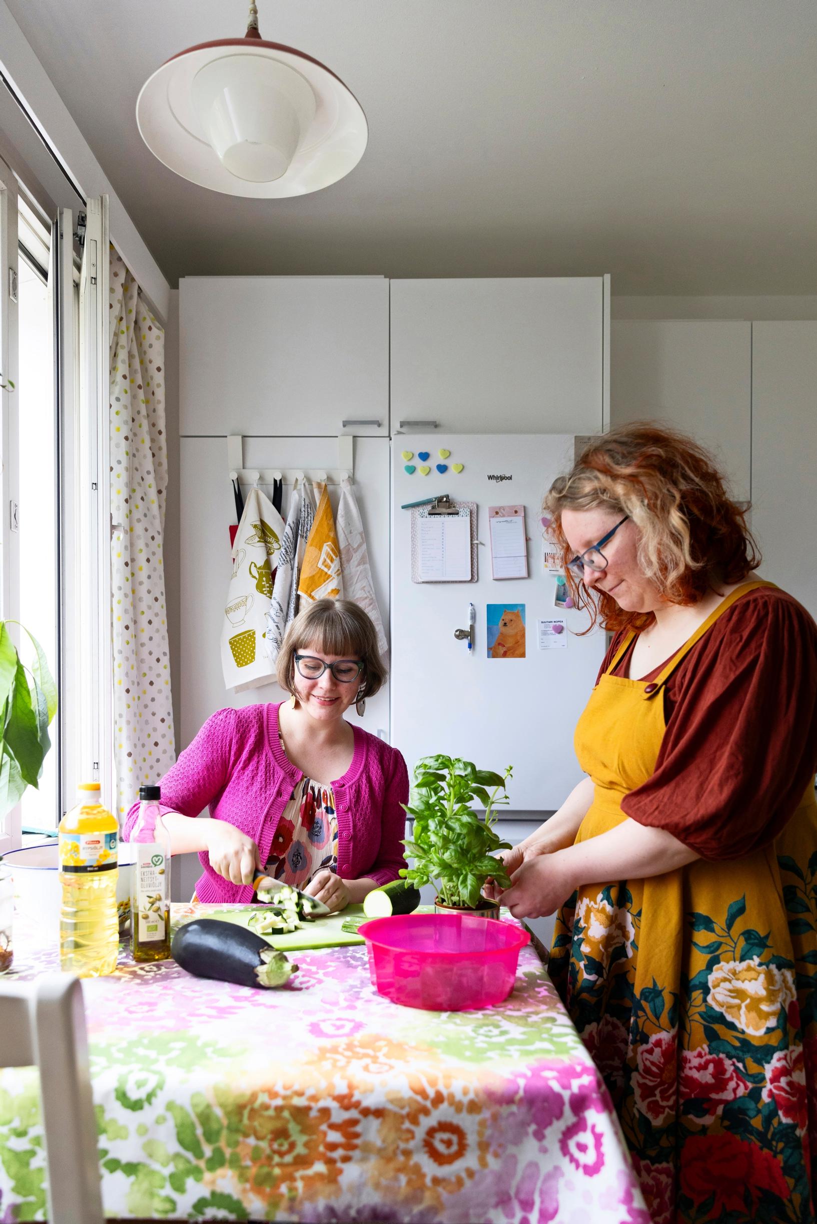 siskokset valmistavat ruokaa keittiön pöydän ääressä
