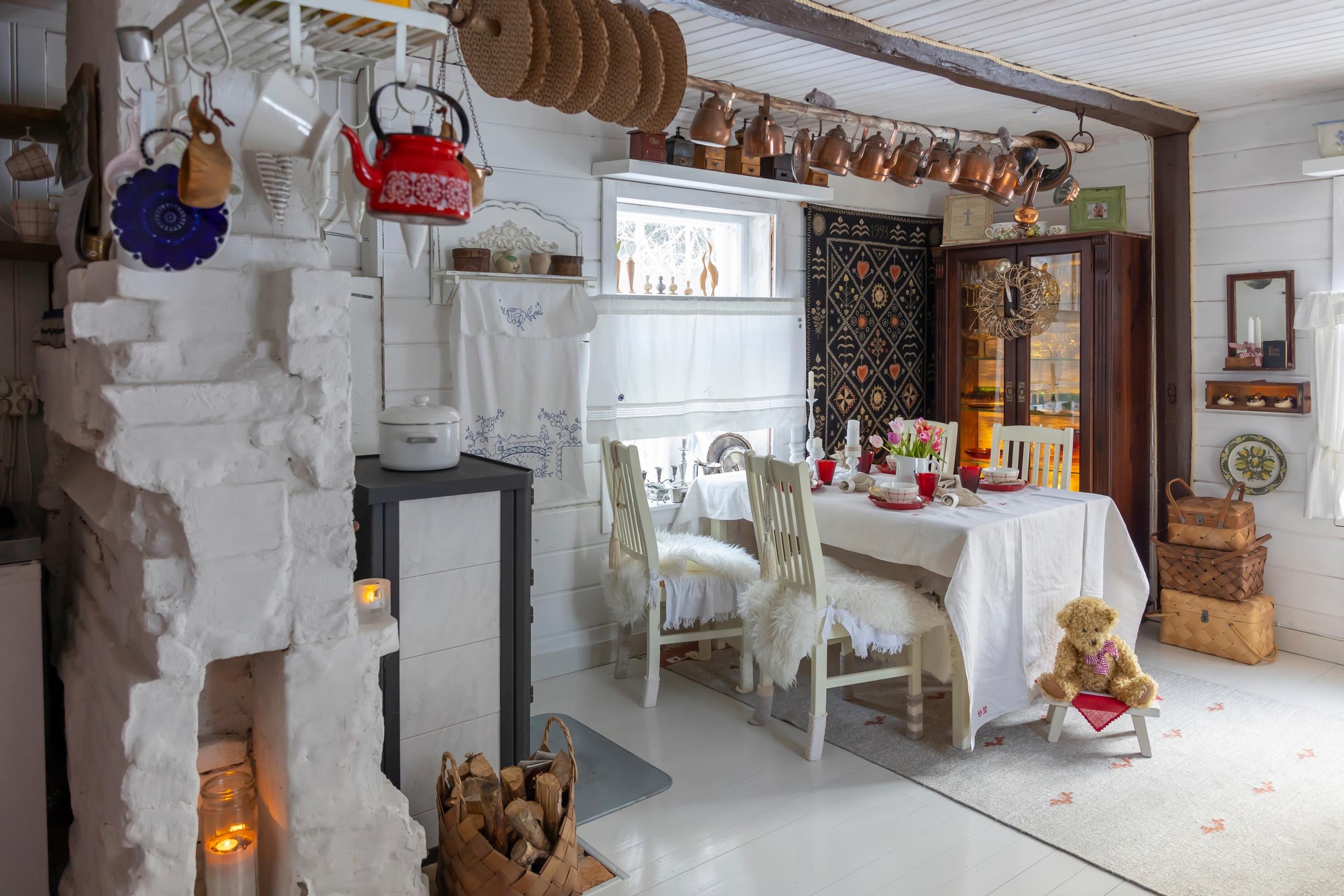 ´vanhan torpan olohuoneessa ruokaryhmä, takka ja vanhoja esineitä