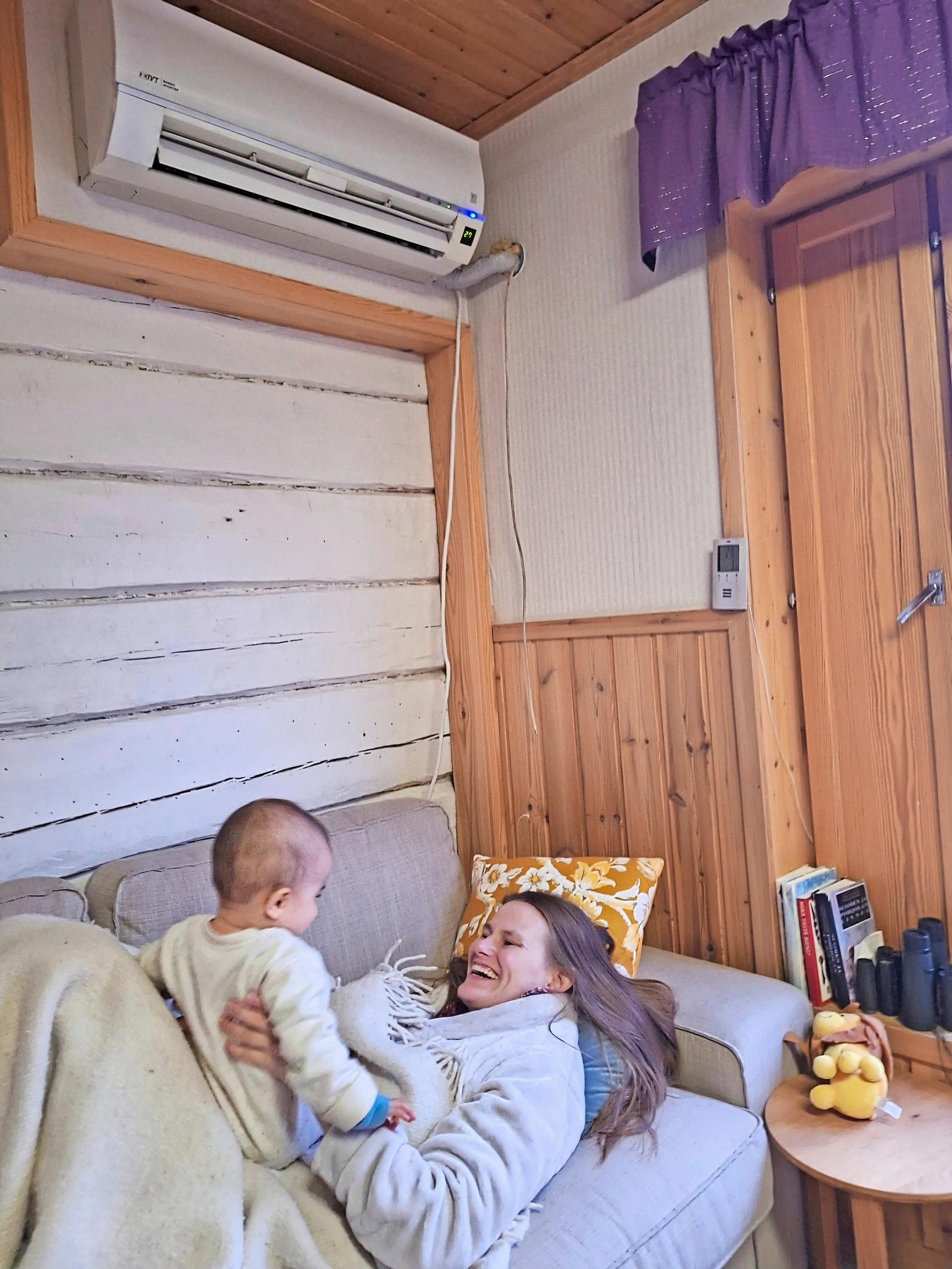 nainen pitää lasta sylissään, molemmat nauravat