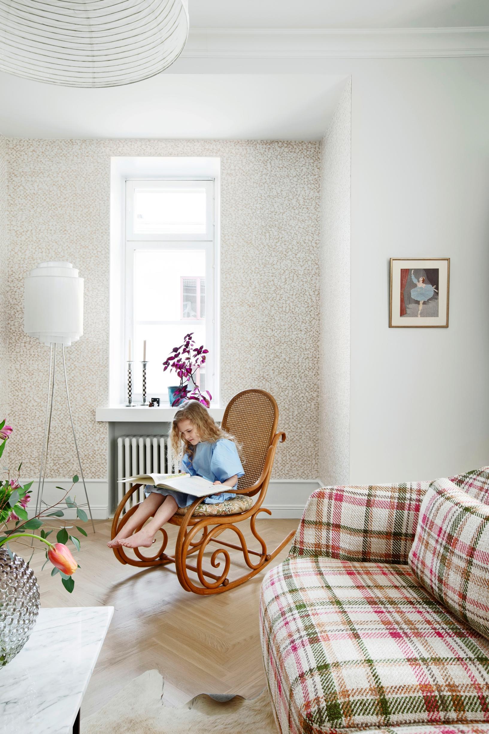 Thonet-keinutuoli ja ruutusohva tv-huoneessa.