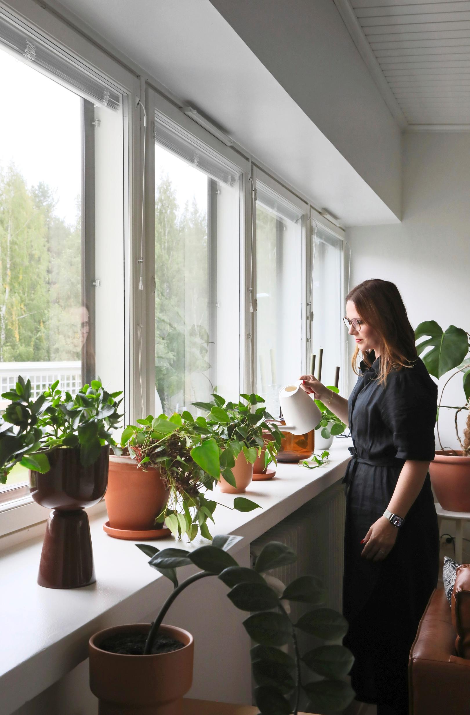 Maarit Kattilakoski kastelee kukkia
