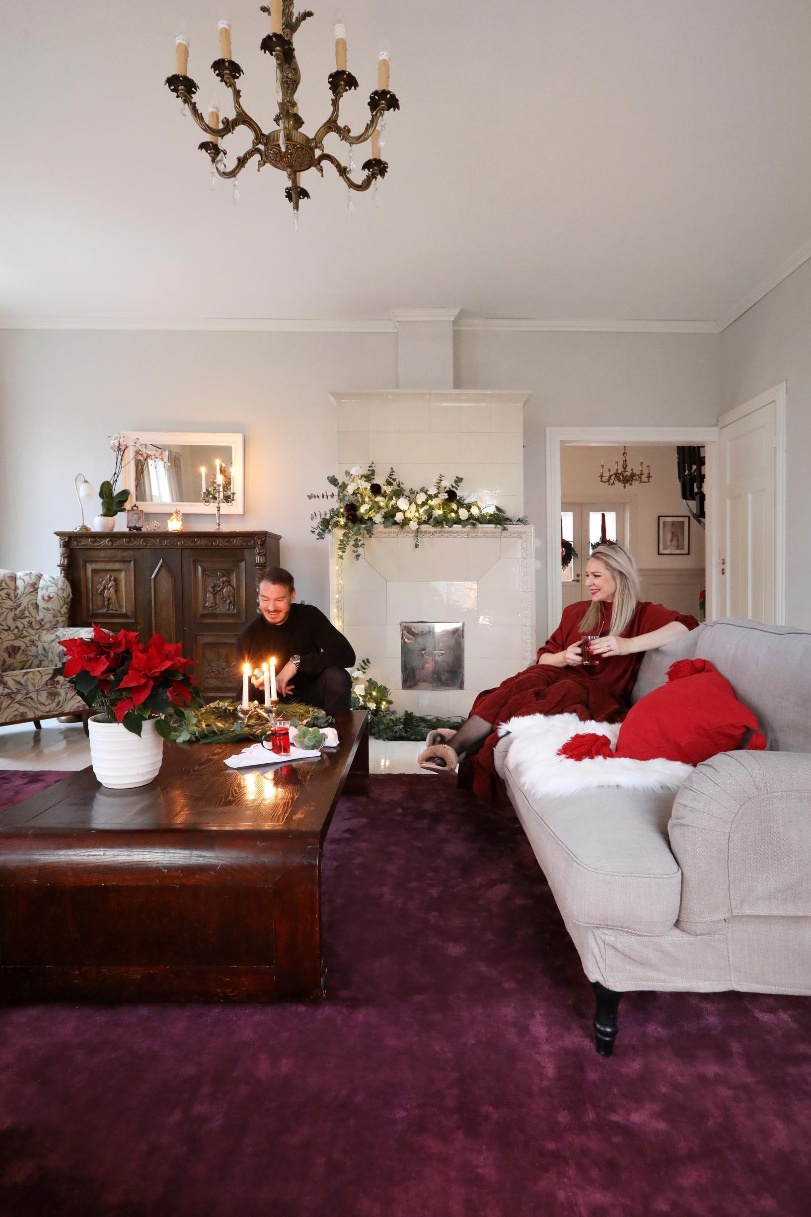 Vaalea olohuone, joka on sisustettu tummilla puuhuonekaluilla ja suurella luumun värisellä matolla