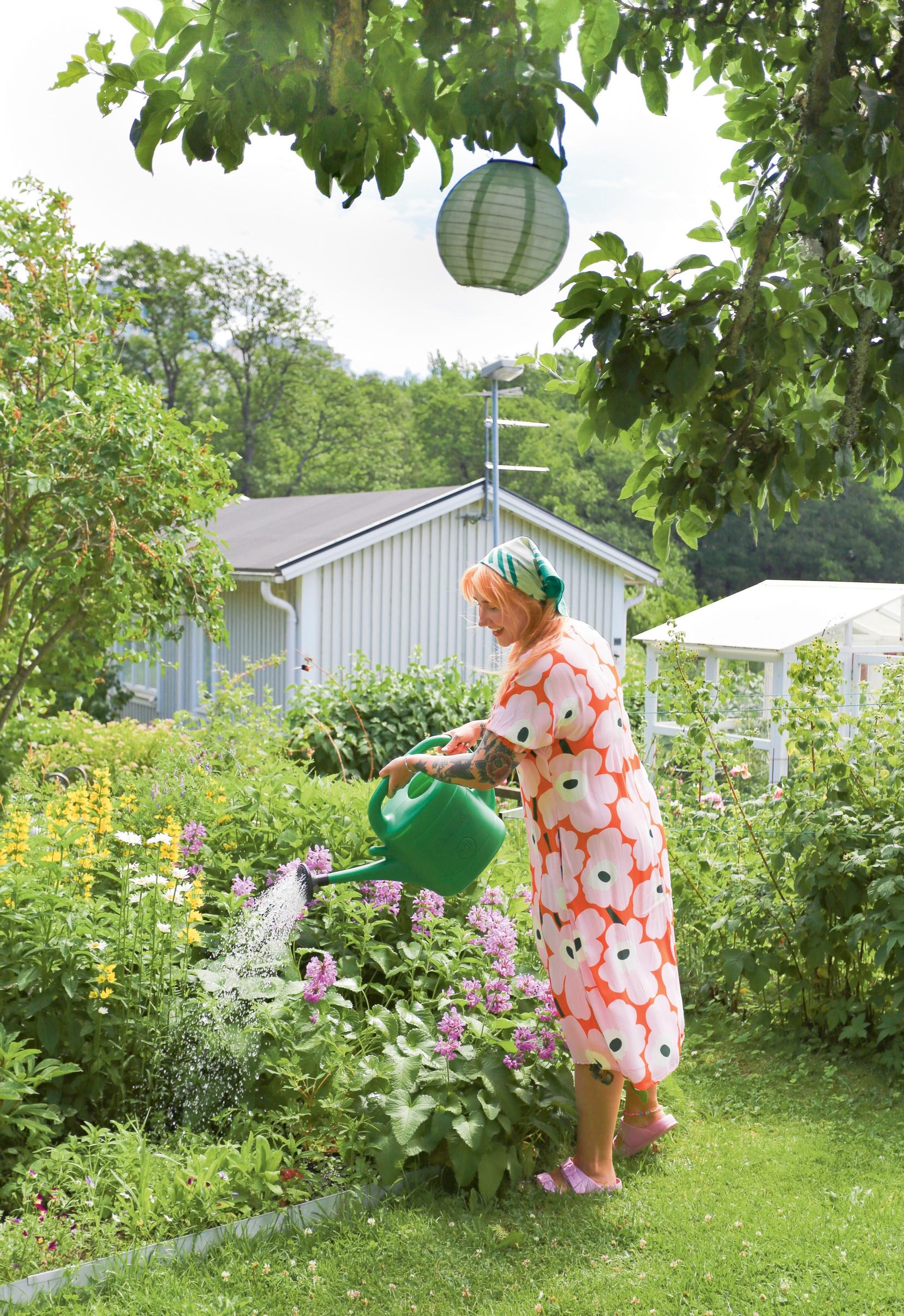 Hanna Paananen kastelee kukkia