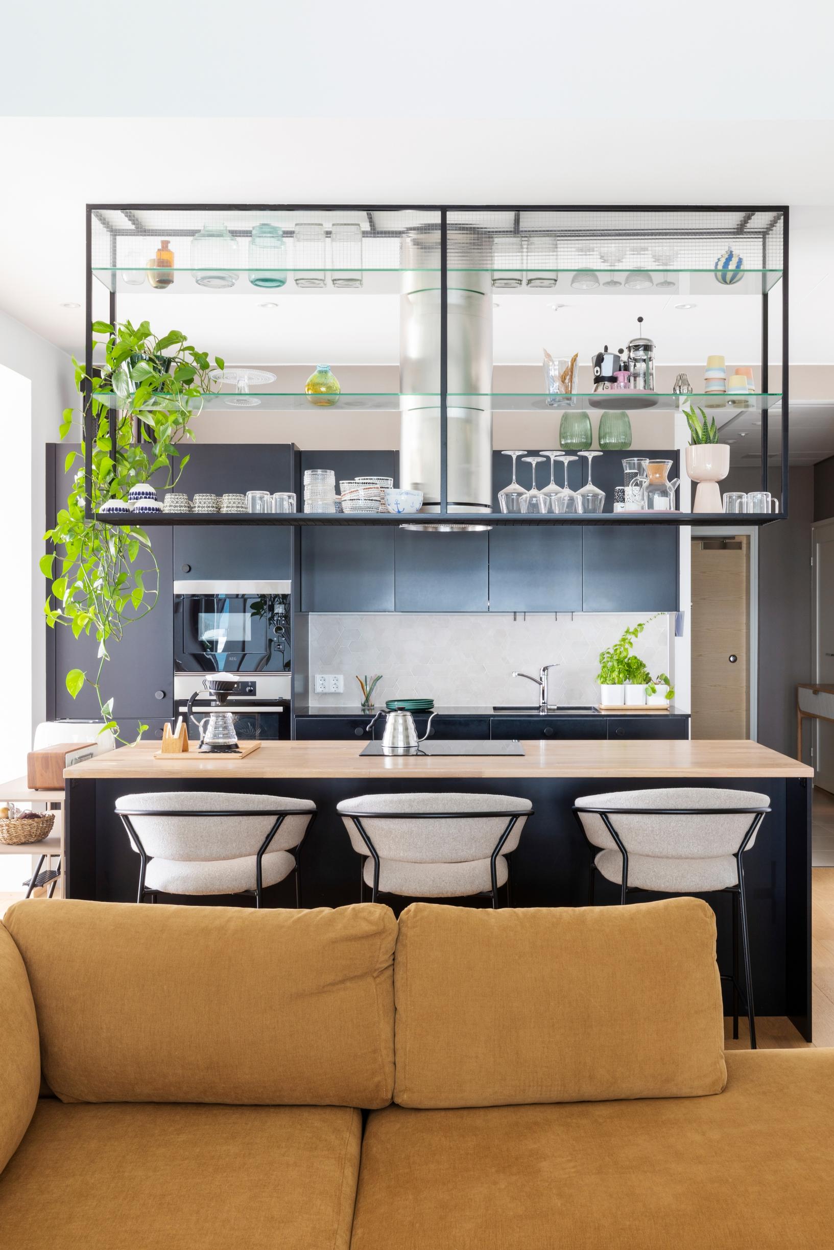 Metallinen, ilmava bistrohylly keittiössä, joka on yhtenäisessä oleskelutilassa