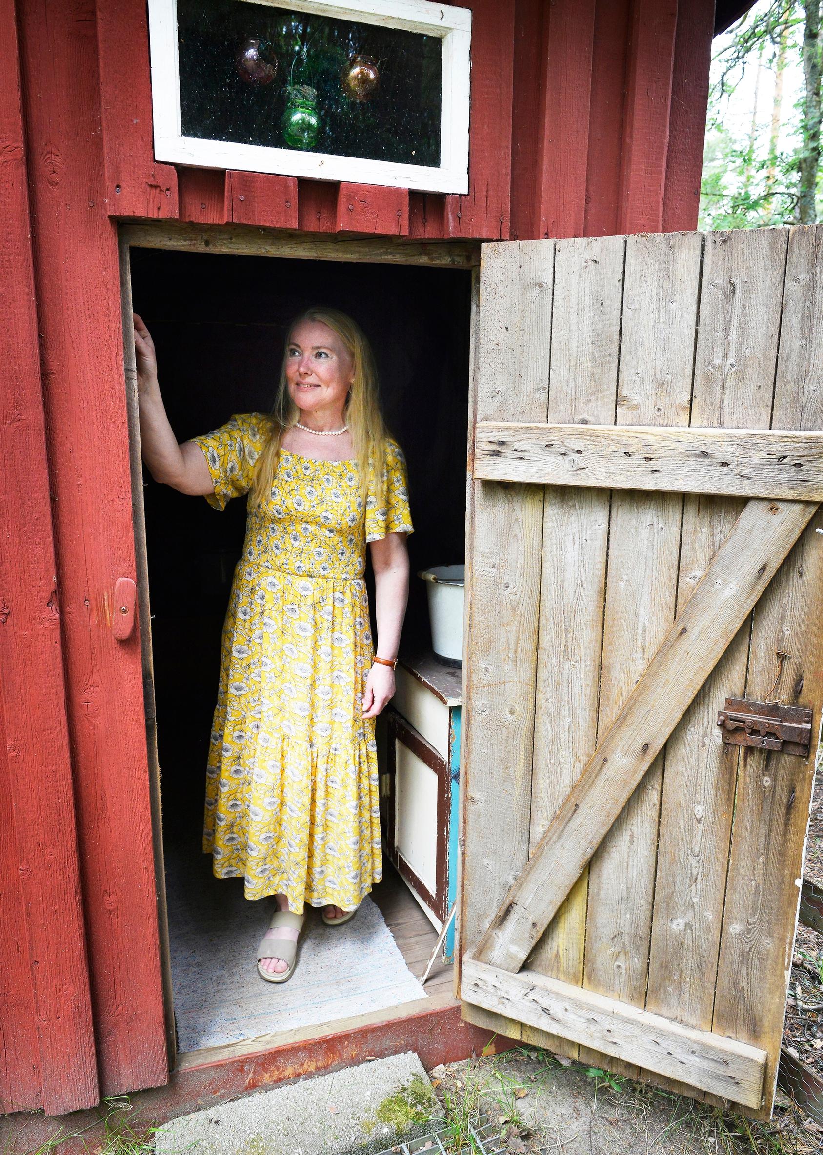 Nainen piharakennuksen ovella