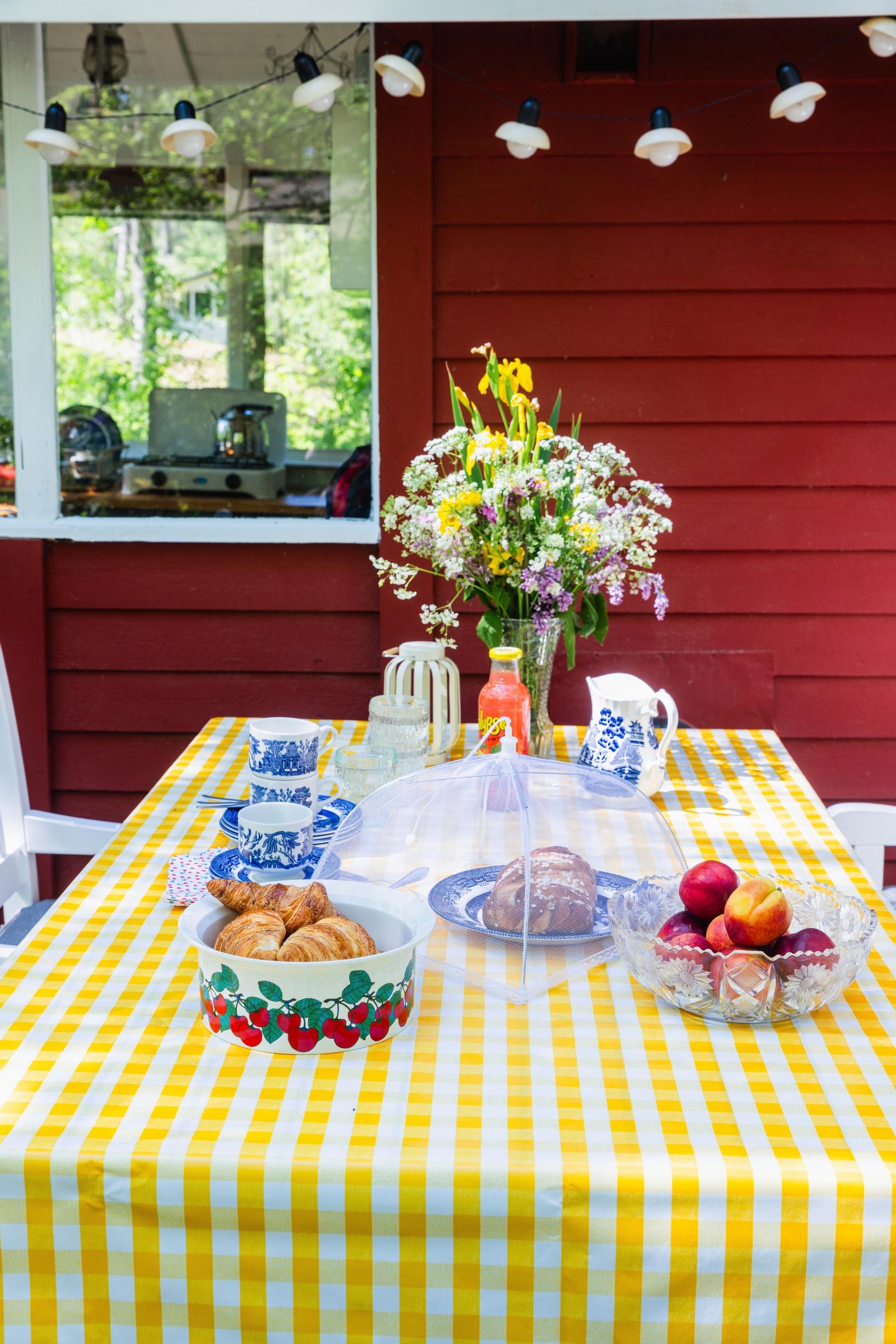 Ruudullinen vahakangas kesämajan terassipöydällä