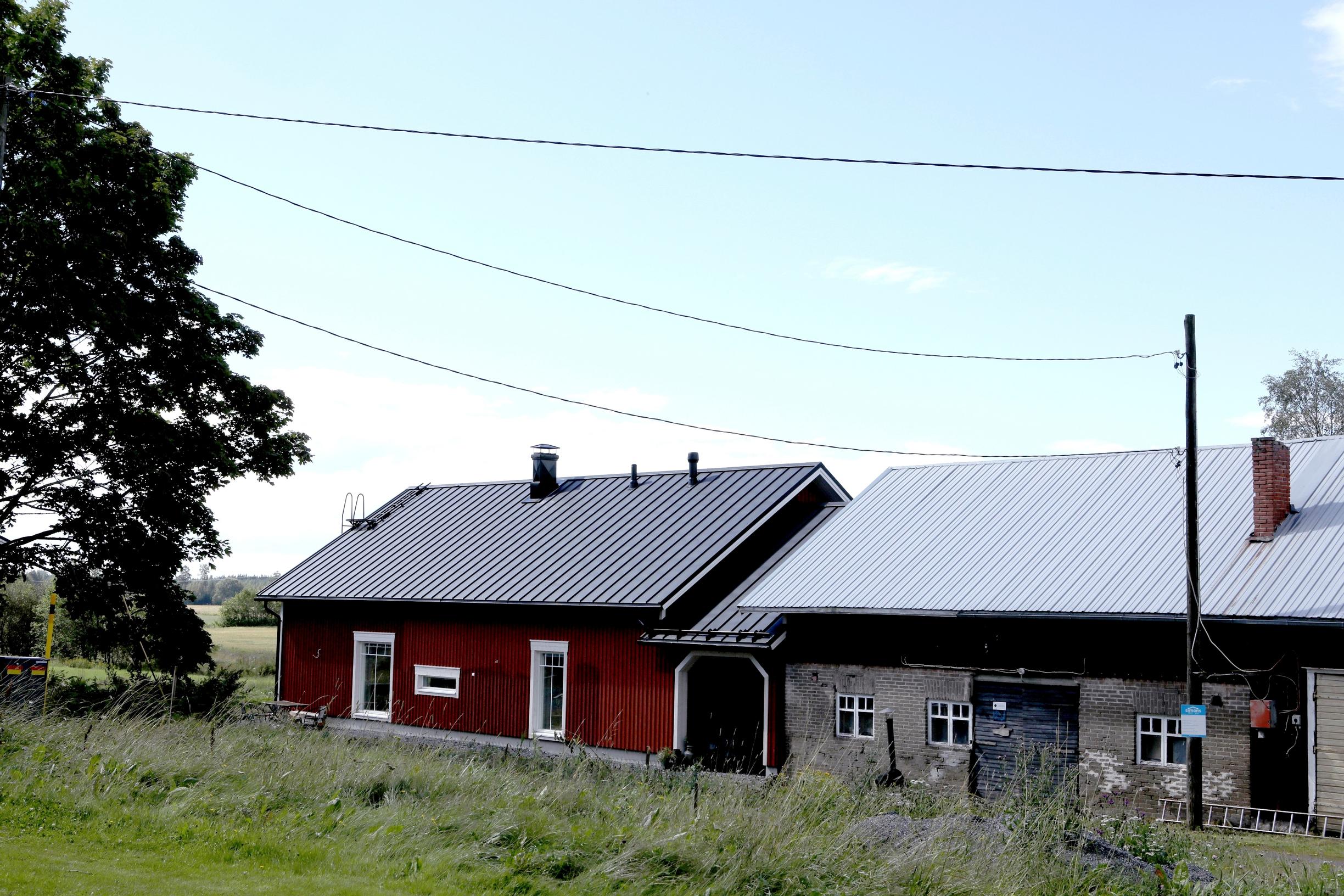 Punainen talo on on yhdistetty harmaaseen navettaan porttikongilla.