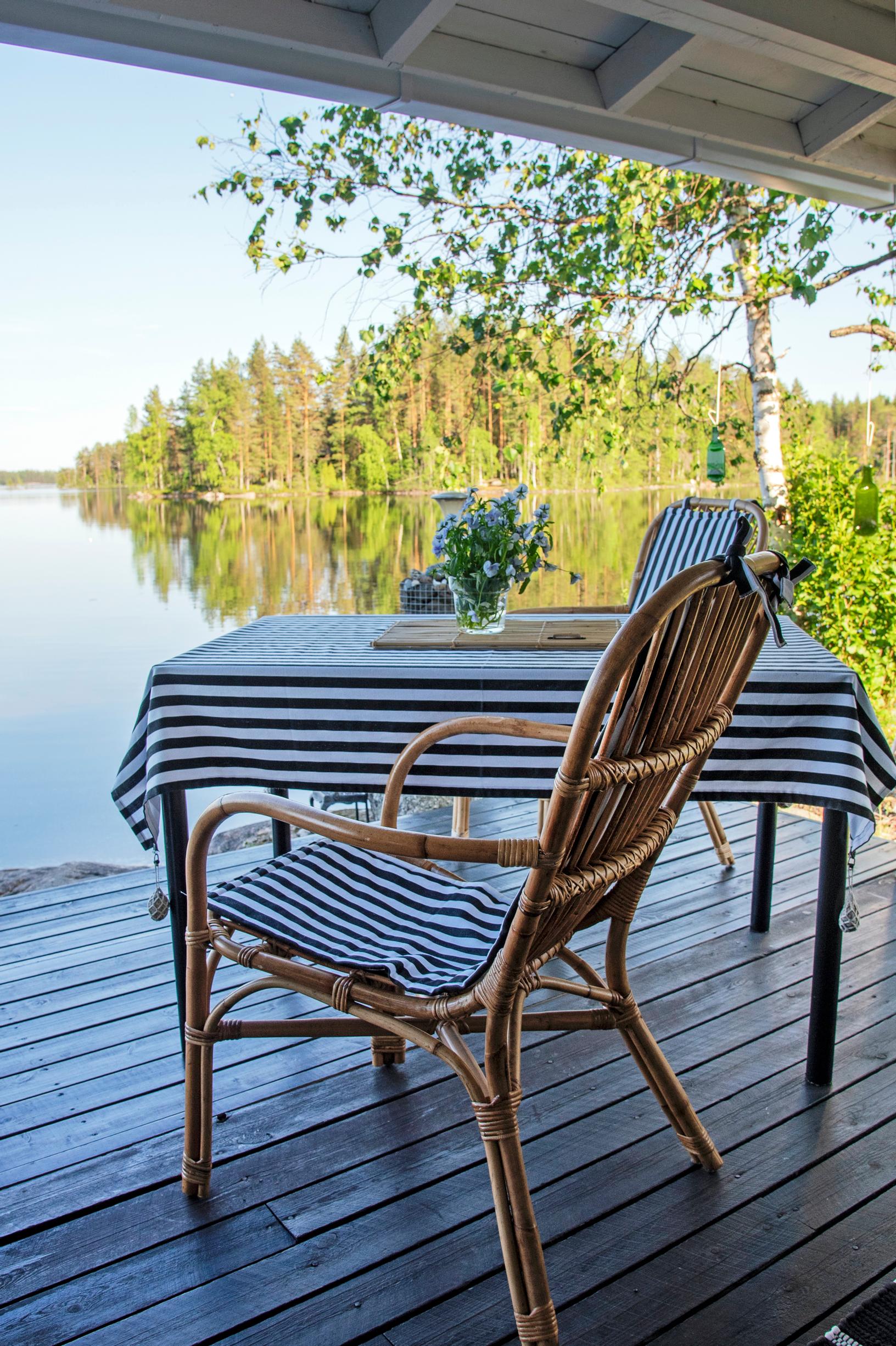 Sinivalkoraidallinen liina terassipöydällä veden äärellä
