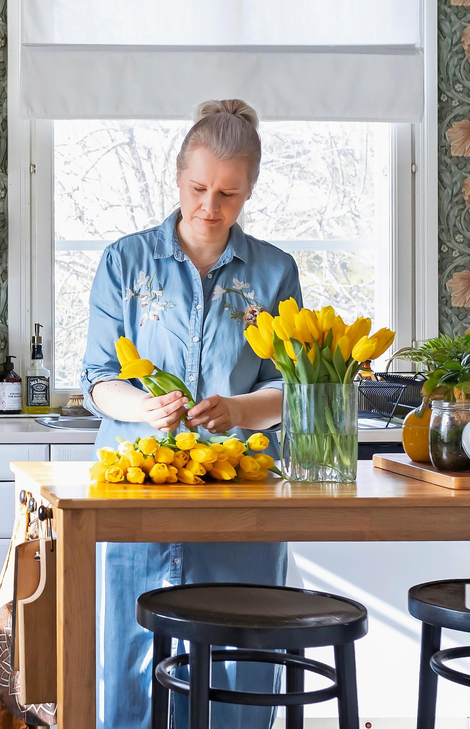 Kirsi Välimaa asettelee keltaisia tulppaaneja