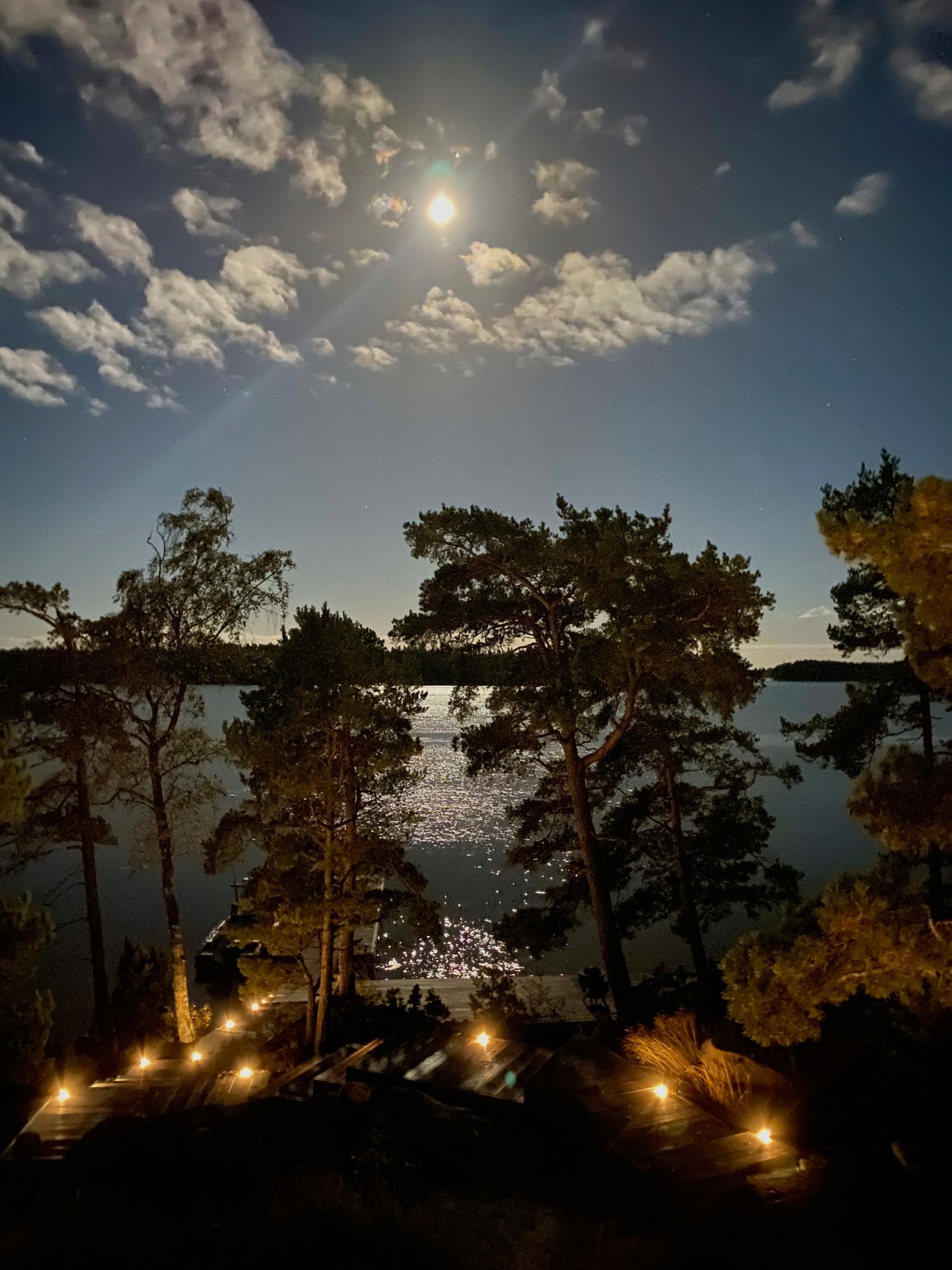 mökin ulkovalaistusta pimeässä, näkymä merelle, jossa kuunsilta