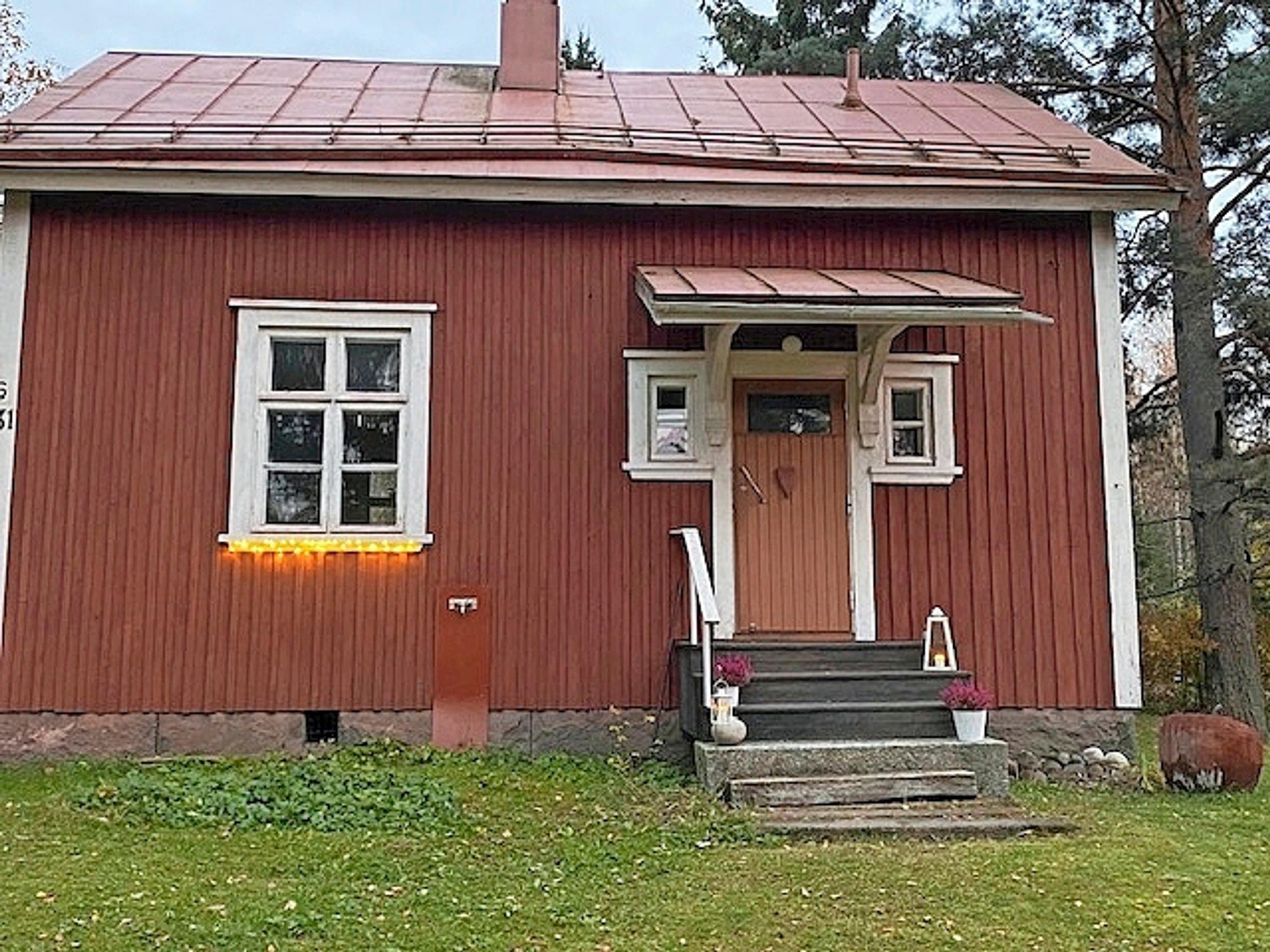 punainen lautarakennus valkoisin ikkunanpuoli ja kiviportaat