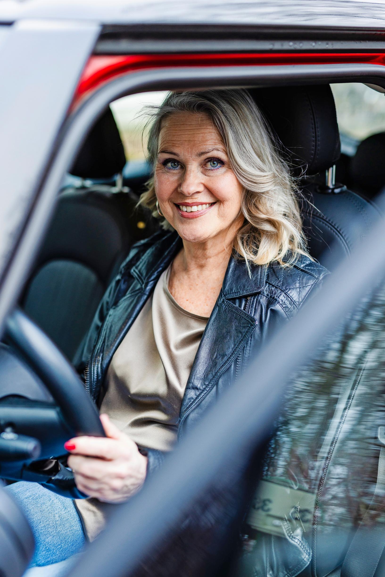 nainen istuu auton ratissa