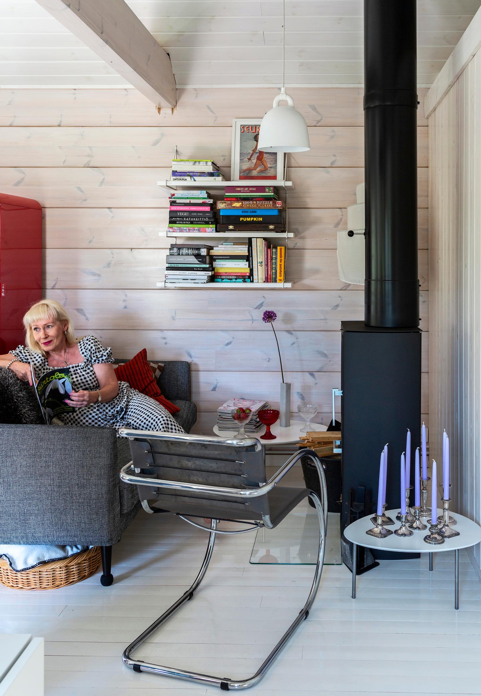 Outi Raatikainen siirtolapuutarhamökkinsä sohvalla