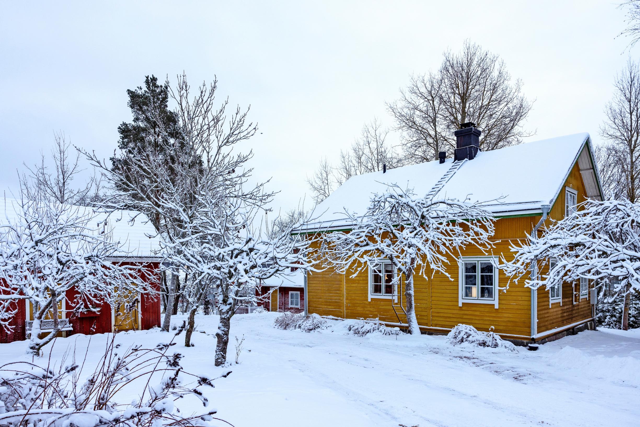 Keltainen puutalo pihapiireineen