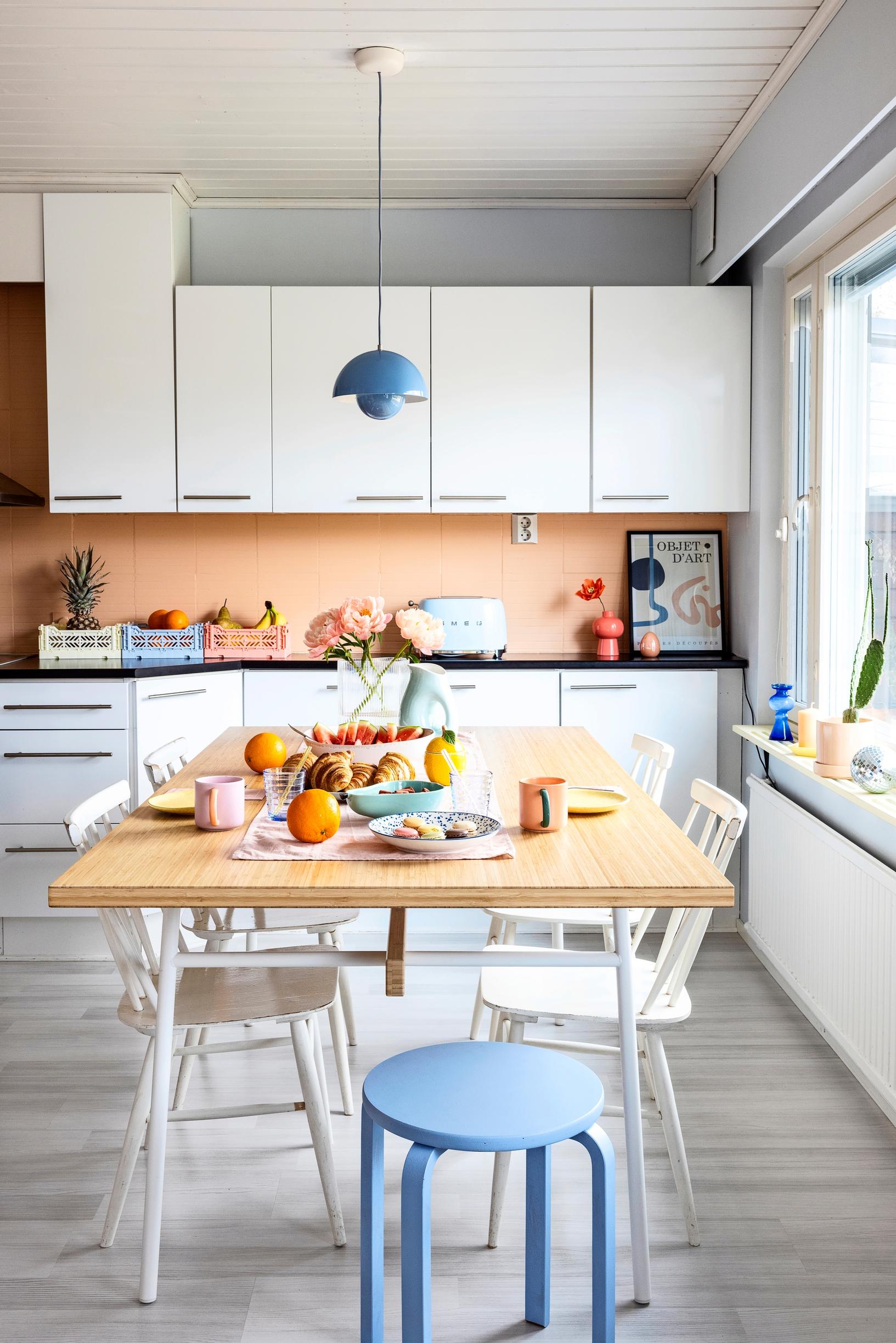 Vaalea keittiö, jossa on värikkäitä yksityiskohtia