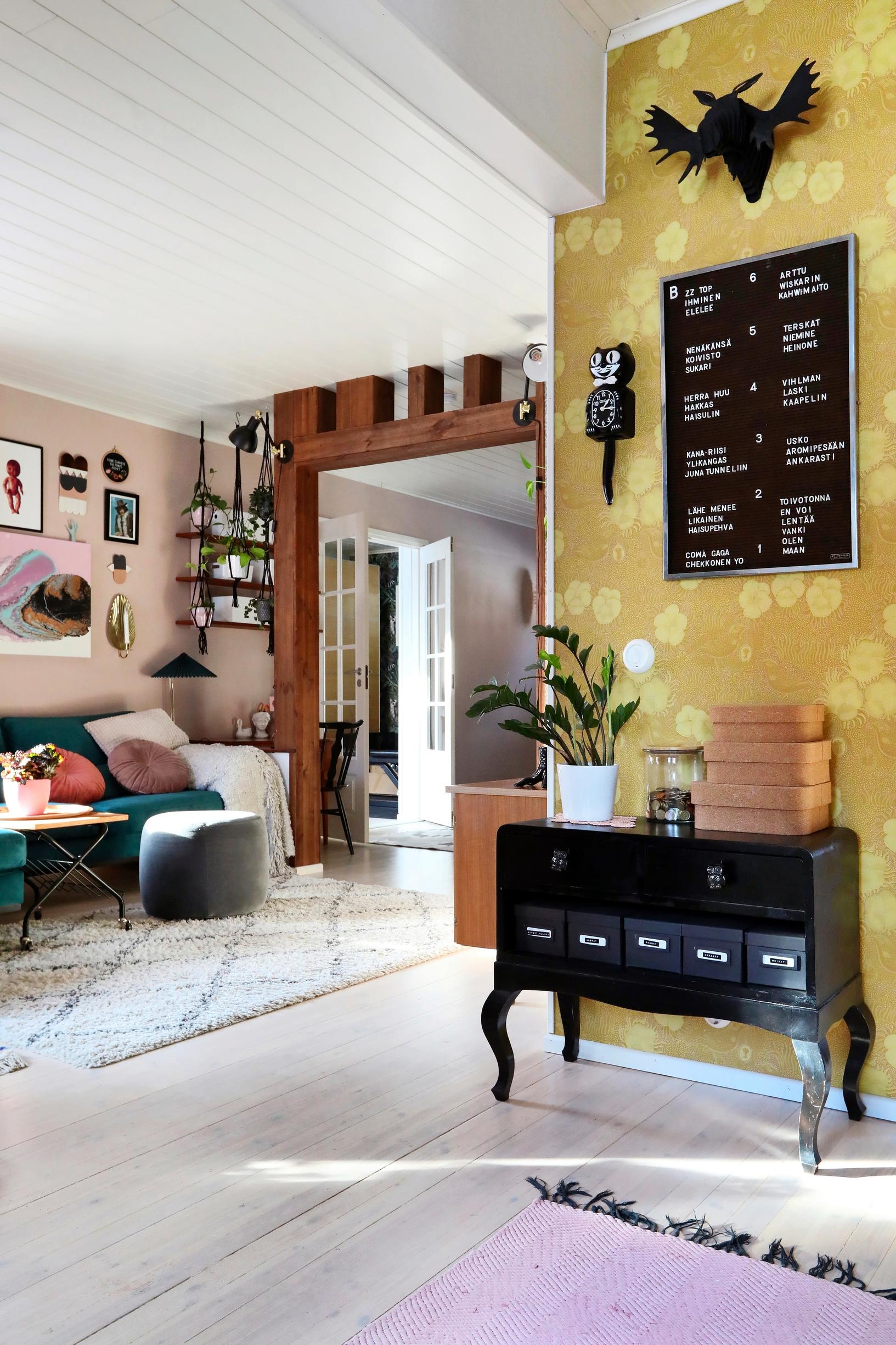 Kiurujen yö -tapetti ja musta koristeellinen lipasto eteisessä