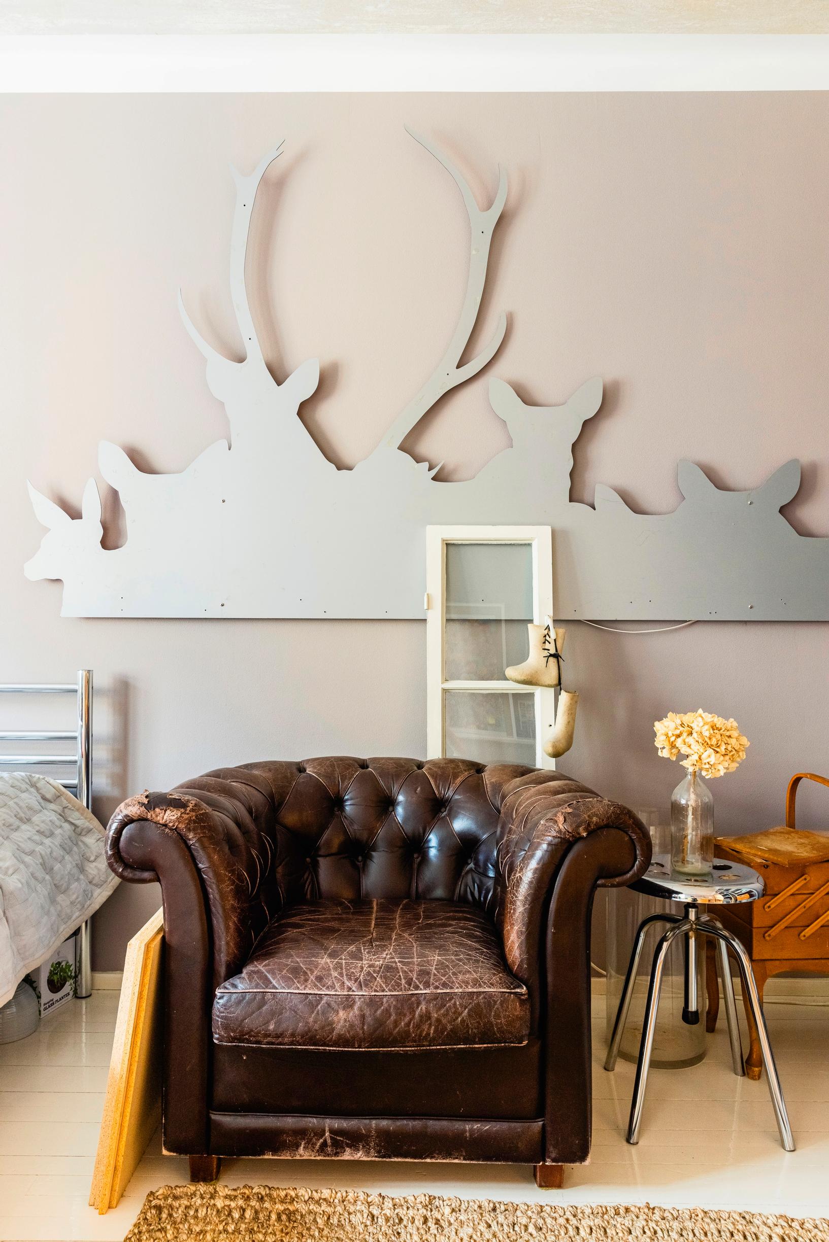 Nahkainen nojaatuoli ja hirviteos seinällä