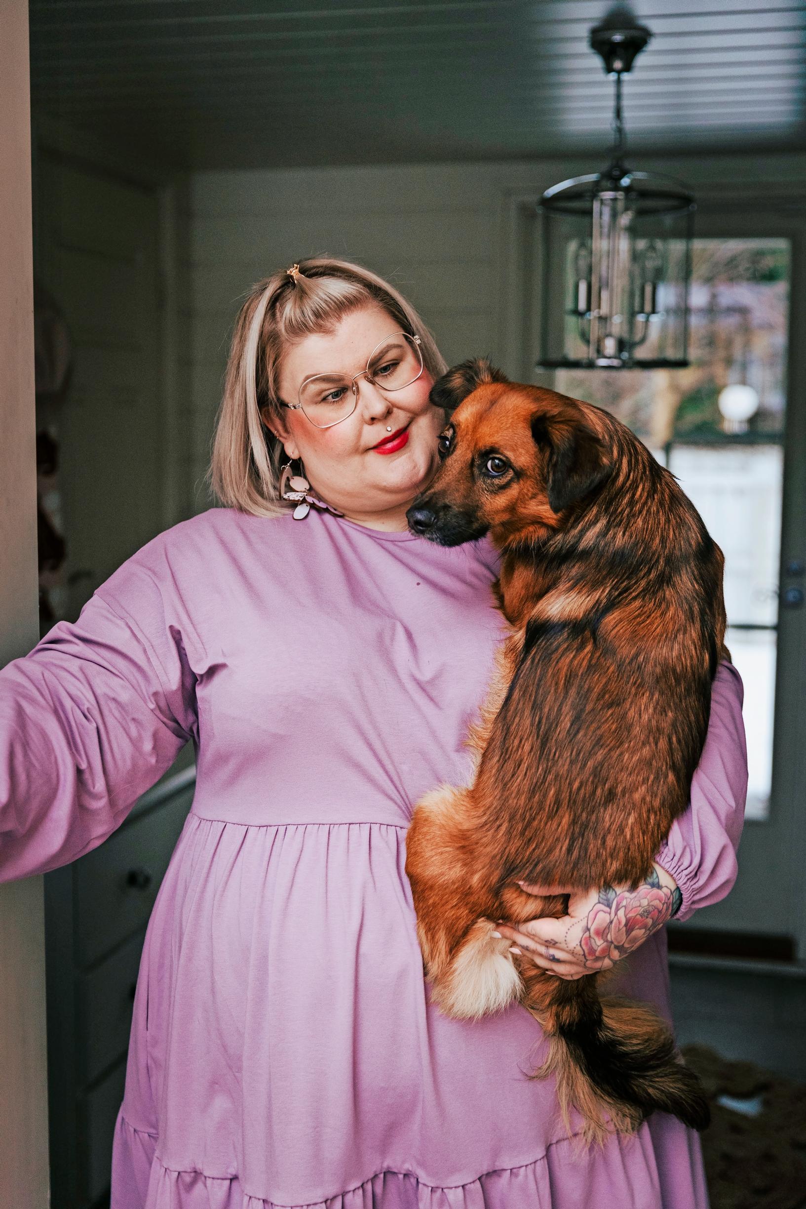 naisen sylissä on koira